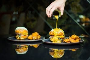 Kól Restaurant food advert showing a burger with bernaise sauce being poured onto it