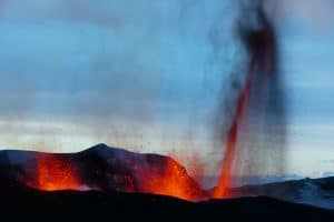 An erupting volcano shooting lava high up in Iceland