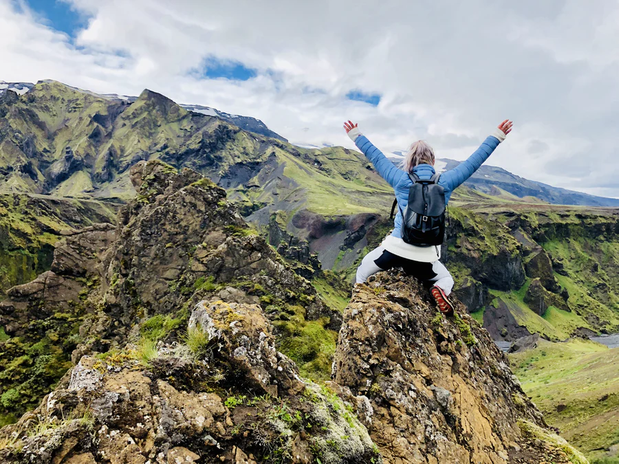 A woman sitting on top of Thormork mountain ridge in Iceland