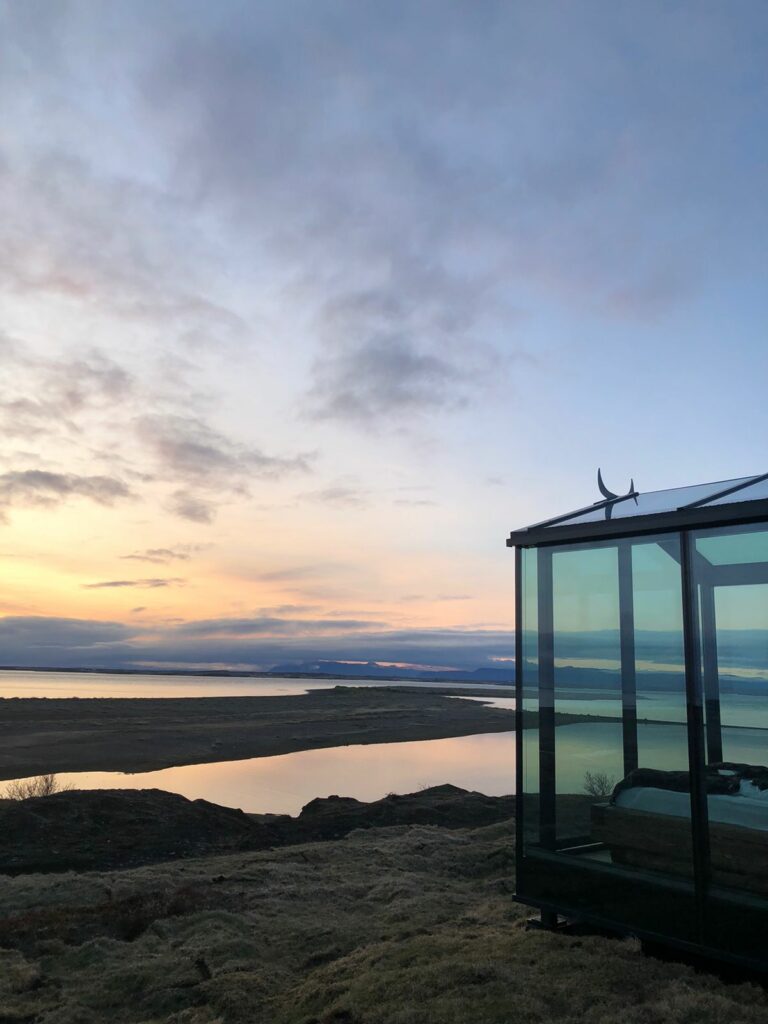 Heimdall glass lodge west iceland with ocean view and sunset