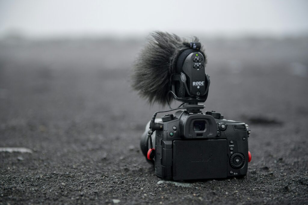 A DSLR camera resting in the black sand in Iceland during summer